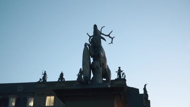 A statue of a deer on a castle square in Stuttgart, Germany. November 25, 2017. 4k video. Evening day