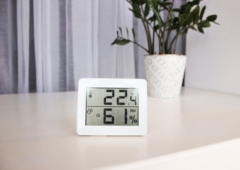 Thermometer hygrometer measuring the optimum temperature and humidity in a house, apartment or office, a photo for articles about the house’s microclimate, health, disease relief and virus treatment - obrazy, fototapety, plakaty