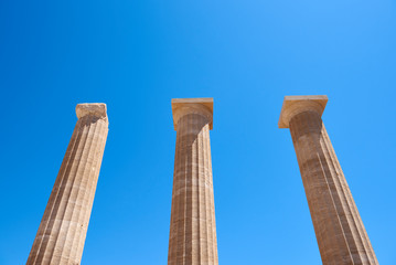 Ancient columns in the Acropolis under blue sky. Lindos town in Rhodes, Greece