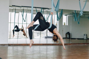 attractive girl in the gym during yoga and fly yoga, posing and looking good