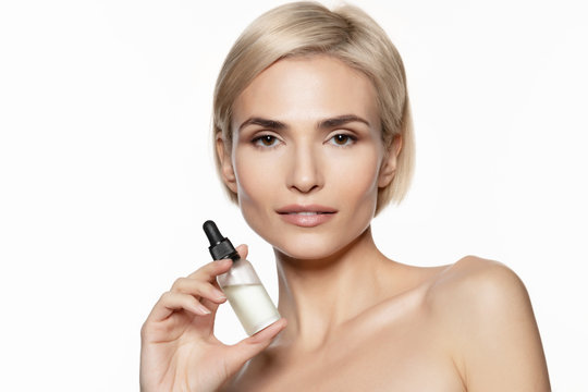 Young  woman with natural  perfect clean fresh skin holding serum oil bottle.