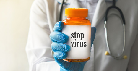 Packing with vitamins in the hands of a doctor in blue medical gloves on a white background