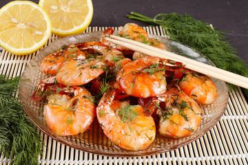 fried king prawns in a plate on a bamboo mat, lemon, dill, close-up