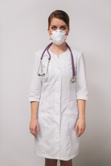 Young woman doctor in a respirator in a medical white coat a professional points