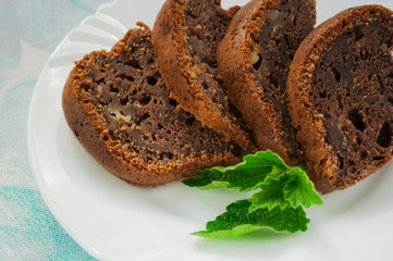 Chocolate cake on a white plate with mint
