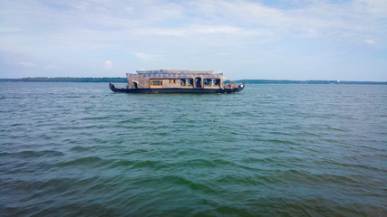 A houseboat in a lake at the Kerala Backwaters in India. Houseboat on Kerala backwaters Ashtamudi Lake.