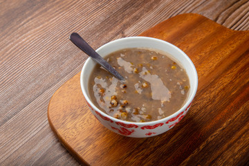 A bowl of delicious homemade Boiled green mung beans on wooden table