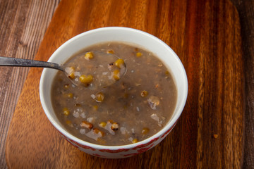 A bowl of delicious homemade Boiled green mung beans on wooden table