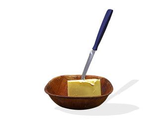 manteca con un cuchillo clavado en un bol de maderar con un fondo blanco.