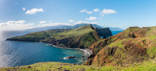 Fototapeta na wymiar View of rugged cliffs and a pebble beach at View of eastern rocky peninsula at Ponta de São Lourenço