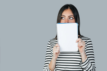 brunette white woman with a notebook with space to write. Mockup