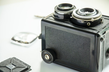 Old TLR camera and Fresnel lens on a white background.