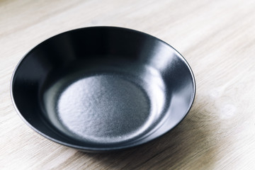 empty black plate on a white wooden table