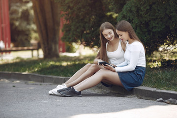 Beautiful girls in a jeans skirts. Women in a summer park.