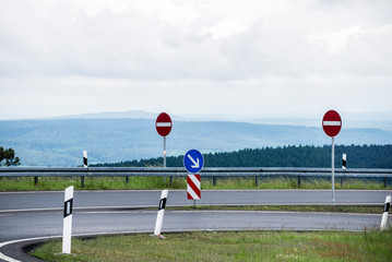 An empty highway with a sharp turn close-up, Germany. Valleys and forests in the background. Dangerous driving concept © Alex Stemmer