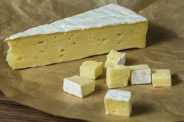 brie cheese. tasting cheese. diced cheese on wrapping paper