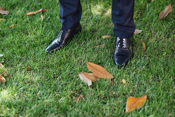 Close-up of a man's shoes before the ceremony on the fresh grass.