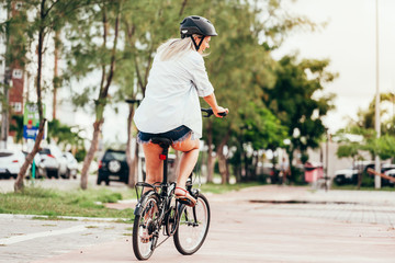 Fototapeta premium Woman riding a bicycle in the park alone due to social distance
