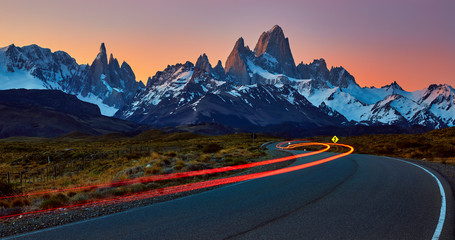 Fitz Roy and Torre massif, at sunset with car light trace on the road to El Chalten.