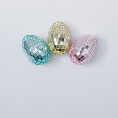 Disco ball Easter eggs in pink, blue and golden pastel colors. Easter holiday creative concept background.