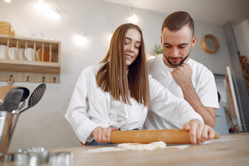 Couple in a kitchen. Blonde in a white shirt. Woman with her boyfriend