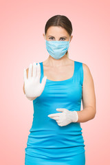 Stop the virus and epidemic diseases. Healthy woman in blue medical protective mask showing gesture stop.
