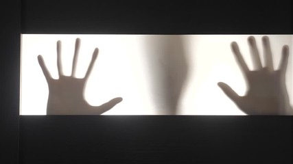 obsessed man maniac scratching glass on hands. silhouette man horror dream ghost. male lifestyle killer silhouette hands knocking on a door