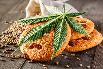 Cookies with cannabis and buds of marijuana on the table. A can of cannabis buds CBD Concept of...