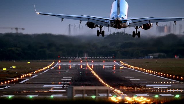 Airplane is landing at HAM Airport at dawn