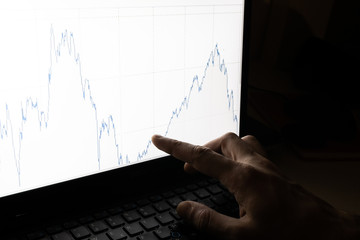 working business man point with finger chart graph evolution of stock market. Market analysis on computer screen. Chart with lines that fall and rise up. Recovery market fund