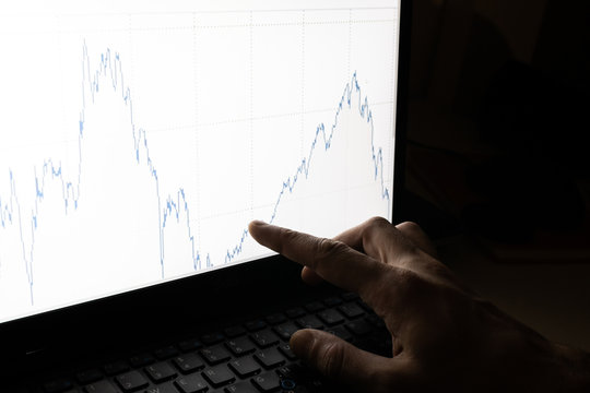 working business man point with finger chart graph evolution of stock market. Market analysis on computer screen. Chart with lines that fall and rise up. Recovery market fund