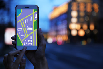 Woman searching location with smartphone in city, closeup. Space for text