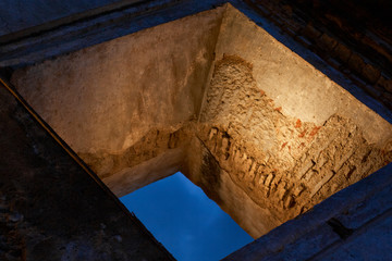 lit old colonial window in ruin against blue sky