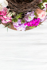 basket of flowers for Mother's Day on wooden table. Handmade decoration for celebration day, as wedding, dining 