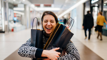 Excited shoppingholic woman in shopping mall.Buying in designer store.Wardrobe sale shopping.Hoby buyer.Weakness for clothes.Clothing shopping after reopening stores.New apparel retail store opened.