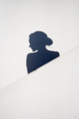 Shadow silhouette of a woman against a white background with a diagonal line across