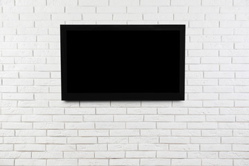 Modern TV on white brick wall. Space for design