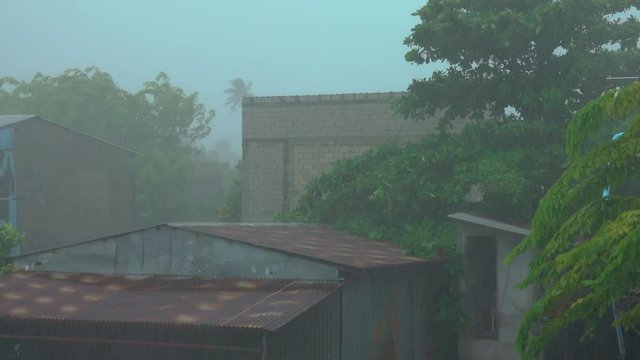 CLOSE UP: Raging tropical storm punishes a small village in the Maldives during rainy season. An intense downpour gathers above the island of Himmafushi. Extreme rainfall during tourist off-season