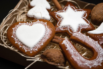 Detail of box with homemade Christmas gingerbread cookies on black background