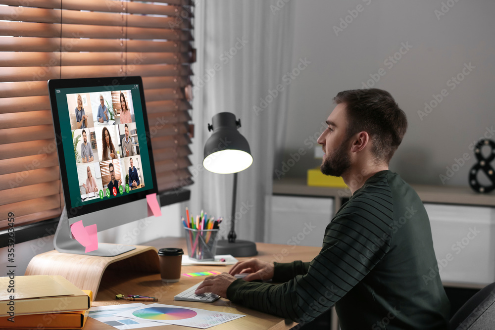 Poster man having video chat with colleagues at table in office. team work