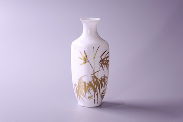 Antique Chinese Eggshell porcelain vase on grey color background. Golden bamboo leaves on White porcelain vase, famous Chinese antique pottery of Ming and Qing dynasties