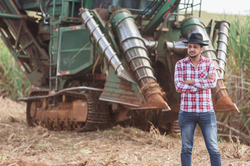 Rural businessman checking work. Sugarcane harvester machine. Farmer.