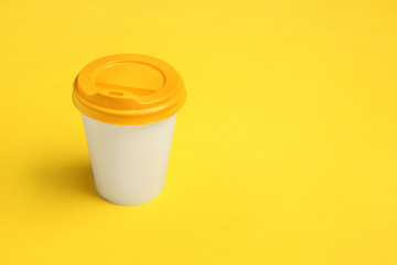 Takeaway cup for drink on color background