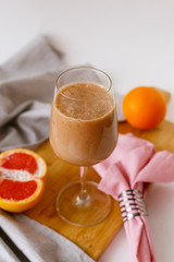 Fruit smoothie in a large glass goblet.  Fruit smoothie on a wooden board.