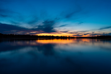 Fototapeta na wymiar lake sunset landscape blue skies orange sun