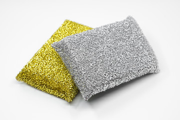 gold and silver kitchen dishwashing sponge. stainless steel spiral scourer pot scraper isolated on white background