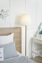 Stylish lamp near bed in room