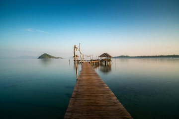 Obraz premium Wooden bar in sea and hut with clear sunrise sky in Koh Mak at Trat, Thailand. Landscape and travel, or nature and sightseeing in summer concept
