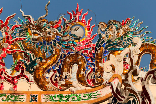 colorful glass mosaic dragon images as roof top decoration in a chinese temple in the city of savannakhet lao PDR