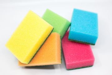 colorful sponges for washing dishes scattered around on a white background